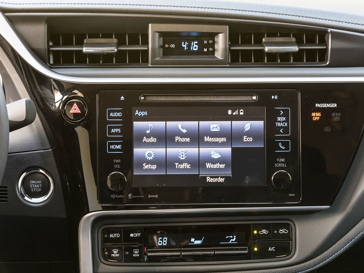 White Toyota Corolla driving on a scenic coastal road